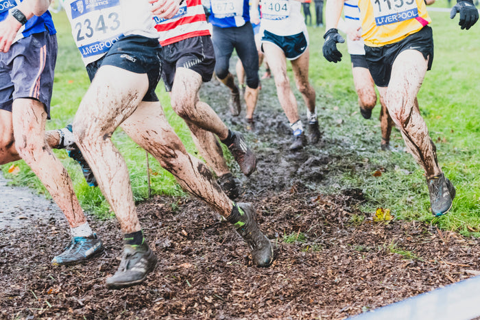 xc spikes v trail shoes in 2024 image shows men competing in cross country spikes in thick mud